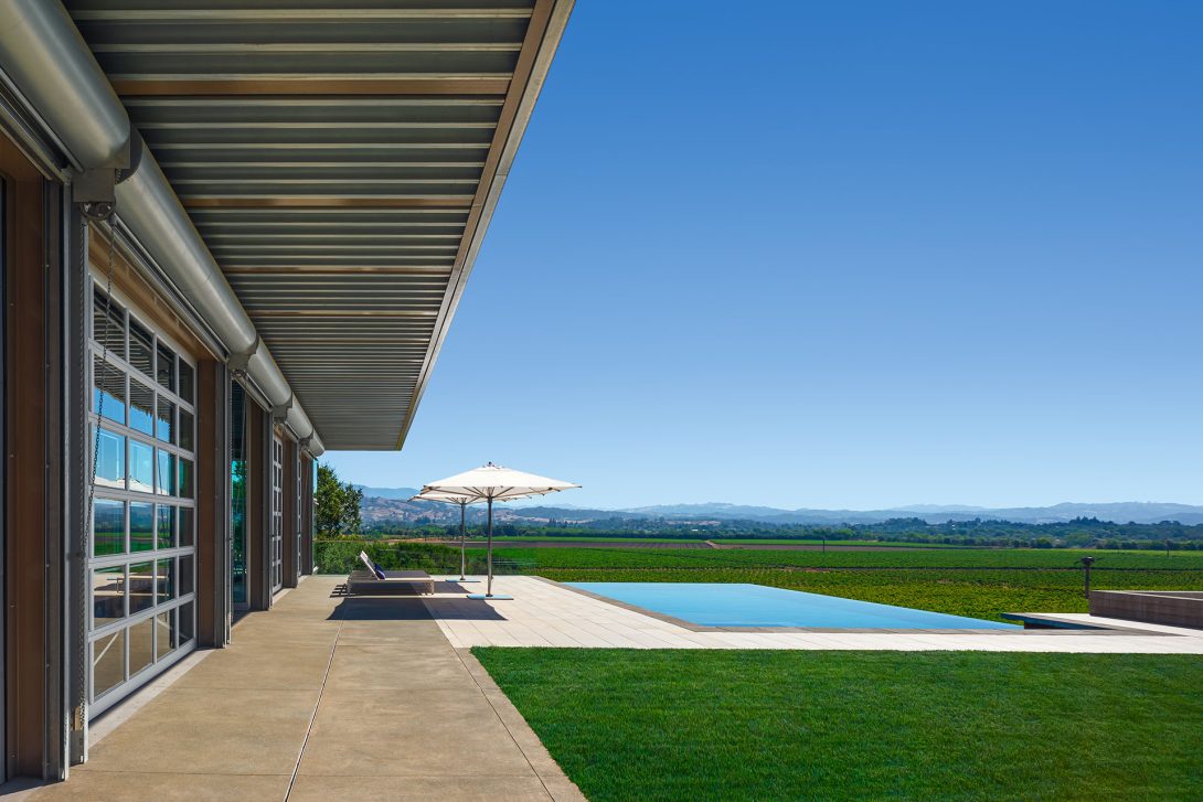 Covered terrace with infinity pool overlooking the vineyards.